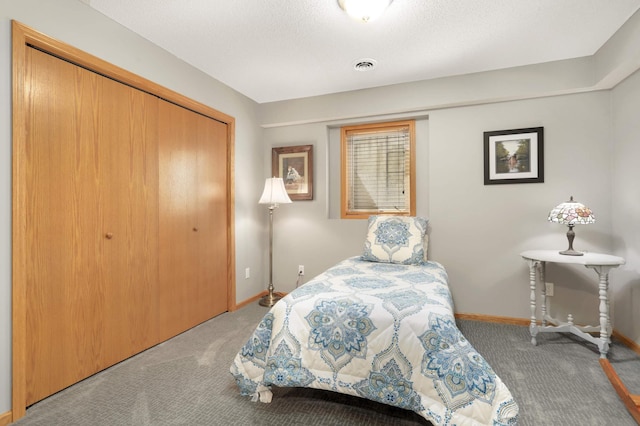 bedroom with a closet, visible vents, carpet floors, and baseboards