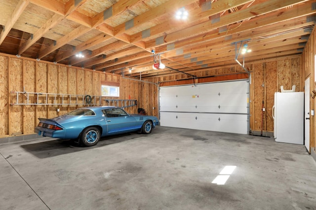garage with freestanding refrigerator and a garage door opener