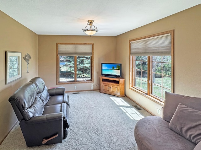carpeted living area with baseboards and visible vents