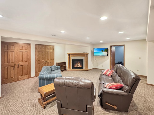 carpeted living room with baseboards, a glass covered fireplace, and recessed lighting