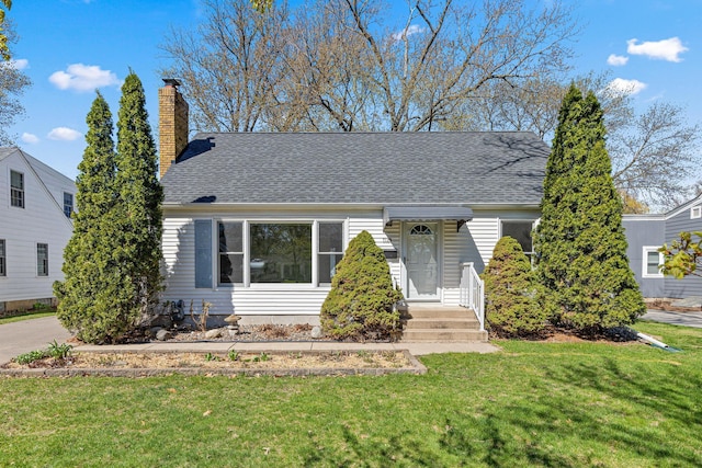 bungalow-style house featuring a chimney, a shingled roof, and a front yard