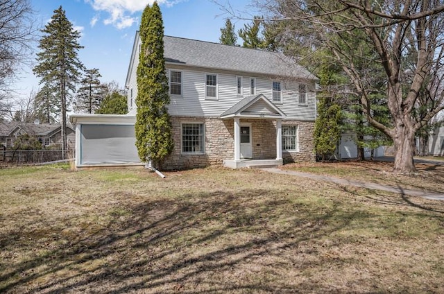 colonial house with fence, stone siding, and a front lawn