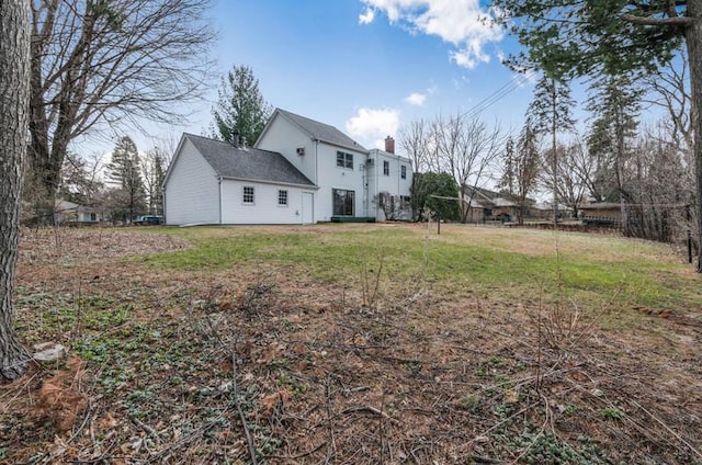back of house featuring fence and a lawn