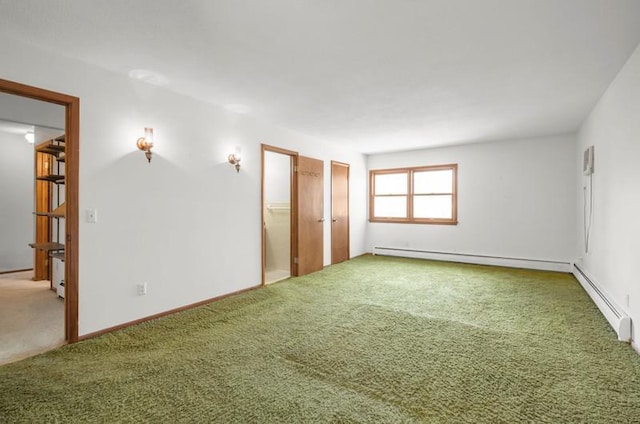 unfurnished room with a baseboard heating unit and carpet floors
