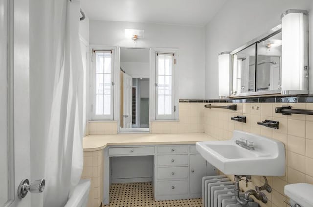 full bathroom featuring a sink, radiator, and shower / bath combo