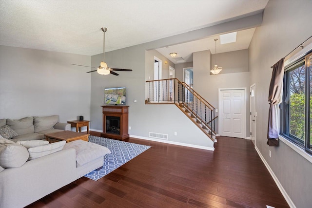 living area with visible vents, a fireplace, wood finished floors, stairway, and baseboards