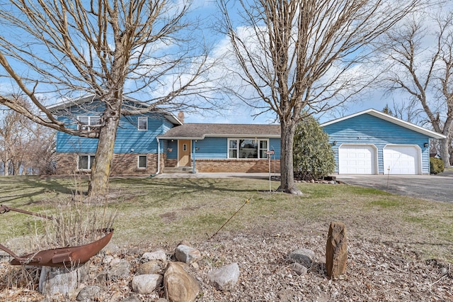 tri-level home with a chimney, a front lawn, driveway, and an attached garage