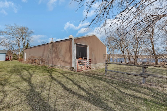 view of pole building with a yard and fence