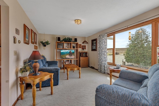 living area with baseboards and light colored carpet