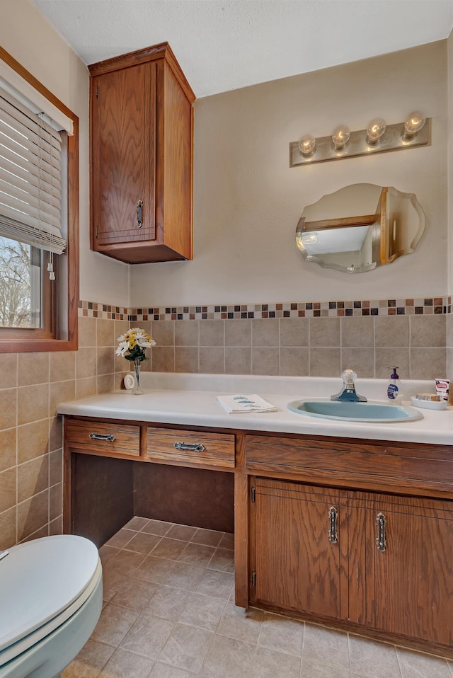 bathroom with tile walls, tile patterned floors, vanity, and toilet