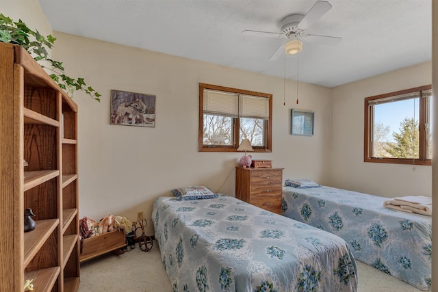 bedroom with a ceiling fan, carpet flooring, and multiple windows