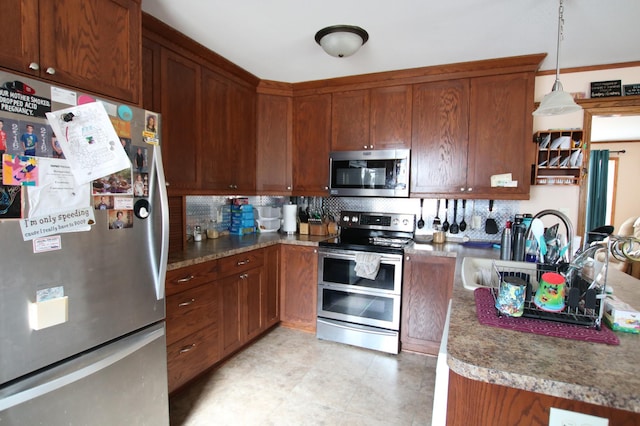 kitchen with decorative light fixtures, decorative backsplash, brown cabinets, and appliances with stainless steel finishes