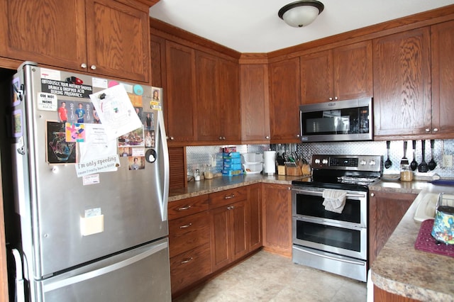 kitchen with backsplash, brown cabinets, stainless steel appliances, and a sink