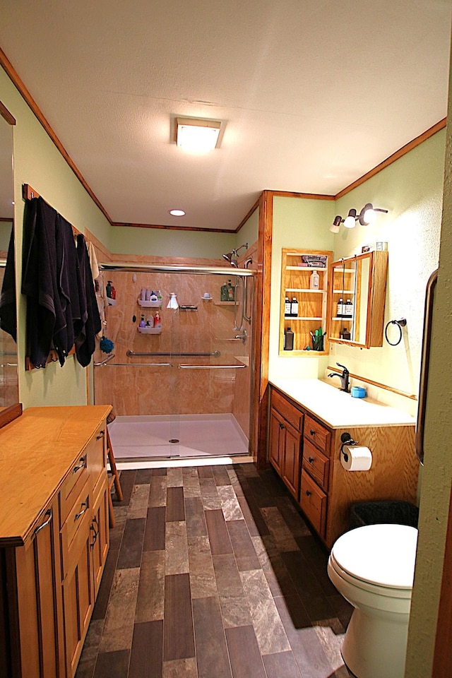 full bath featuring toilet, wood finished floors, a shower stall, crown molding, and vanity