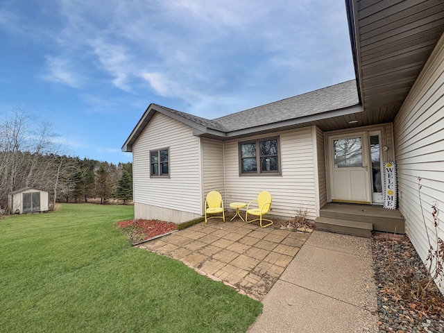 property entrance featuring a patio area, a lawn, and roof with shingles