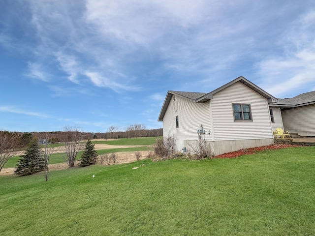 view of side of home with a lawn and a shingled roof