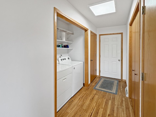 laundry room with separate washer and dryer, laundry area, and light wood-style flooring