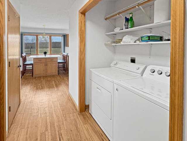 laundry room featuring light wood-style flooring, washing machine and clothes dryer, and laundry area