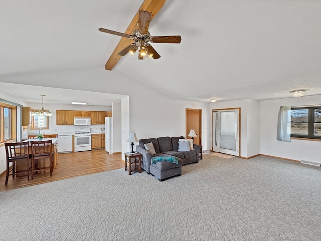living area with ceiling fan with notable chandelier, vaulted ceiling with beams, light wood-type flooring, light carpet, and visible vents