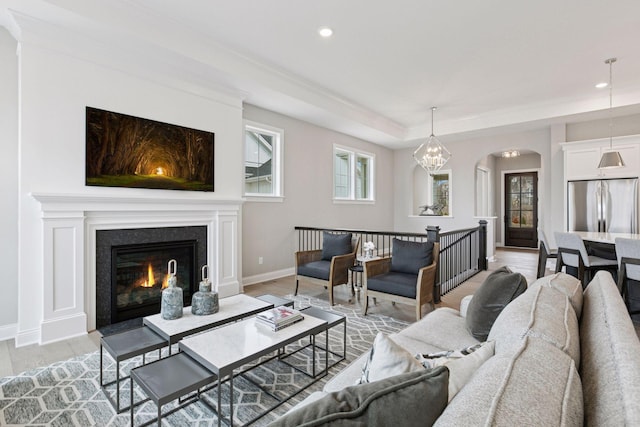 1571 Marsh Pointe Ct, Medina, MN 55340 - living room featuring a glass covered fireplace, light wood-type flooring, baseboards, recessed lighting, and arched walkways