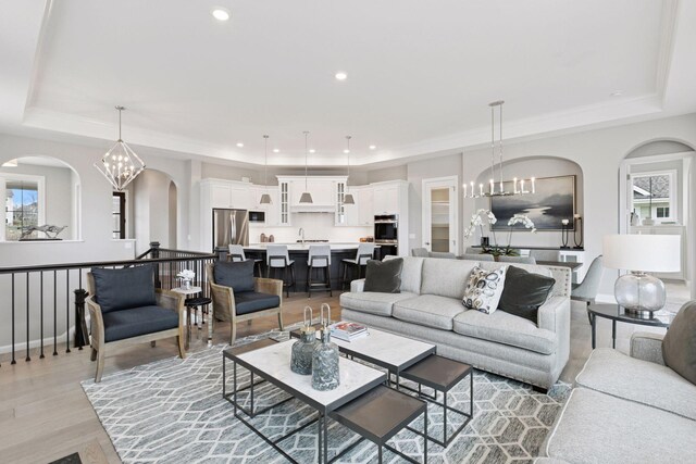 1571 Marsh Pointe Ct, Medina, MN 55340 - living area with a tray ceiling, arched walkways, and an inviting chandelier