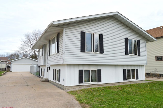 rear view of property with an outdoor structure, a yard, and a garage