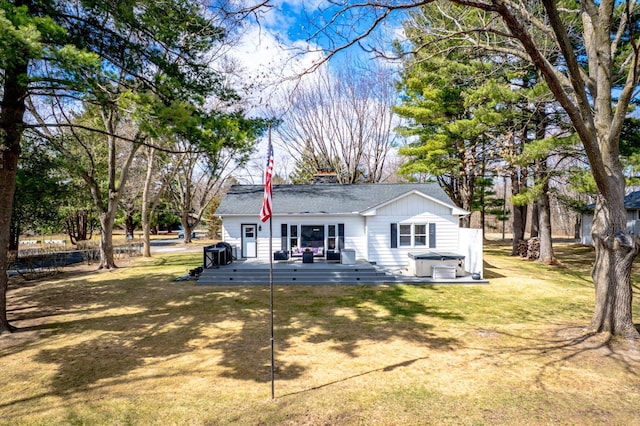 312 Walnut St, Taylors Falls, MN 55084 - back of house with a hot tub, a wooden deck, a chimney, and a lawn
