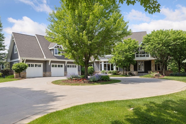9726 Whistling Valley Rd, Lake Elmo, MN 55042 - view of front of home featuring stone siding, driveway, an attached garage, a front yard, and a shingled roof