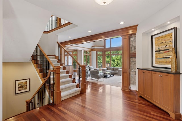 9726 Whistling Valley Rd, Lake Elmo, MN 55042 - staircase with ornate columns, wood finished floors, and recessed lighting