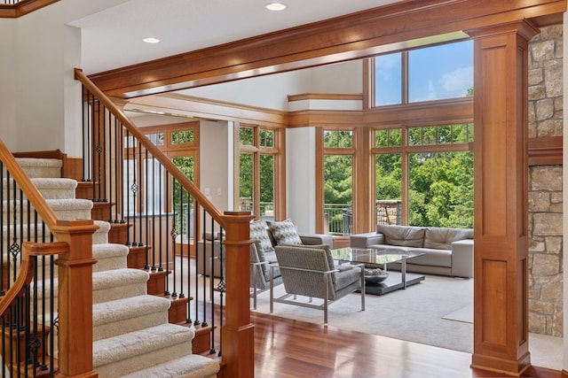9726 Whistling Valley Rd, Lake Elmo, MN 55042 - staircase with ornate columns, wood finished floors, ornamental molding, recessed lighting, and carpet