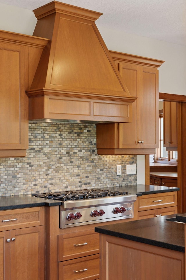 9726 Whistling Valley Rd, Lake Elmo, MN 55042 - kitchen featuring custom exhaust hood, dark countertops, stainless steel gas stovetop, and tasteful backsplash