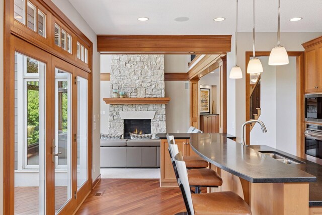 9726 Whistling Valley Rd, Lake Elmo, MN 55042 - kitchen with dark countertops, stainless steel oven, wood finished floors, a sink, and black microwave