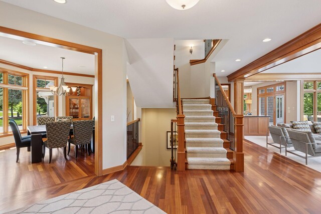 9726 Whistling Valley Rd, Lake Elmo, MN 55042 - entryway with wood finished floors, stairs, a chandelier, recessed lighting, and baseboards