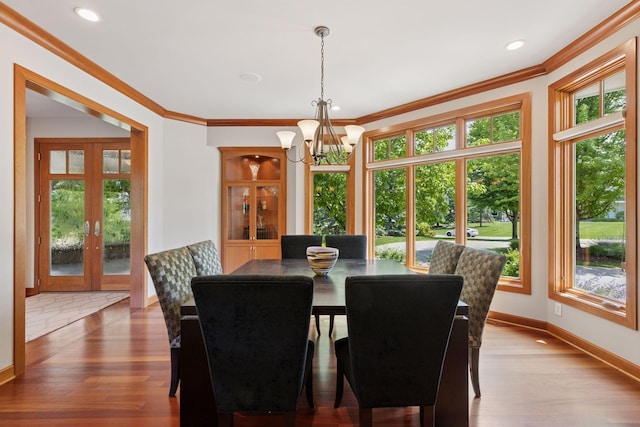 9726 Whistling Valley Rd, Lake Elmo, MN 55042 - dining area featuring healthy amount of natural light, a chandelier, ornamental molding, french doors, and wood finished floors