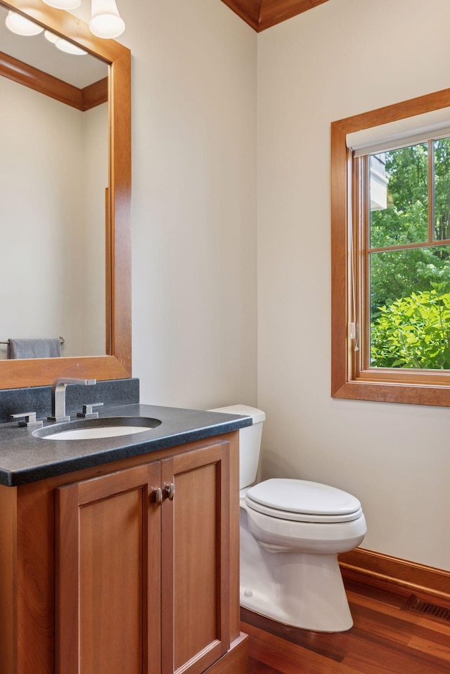 9726 Whistling Valley Rd, Lake Elmo, MN 55042 - half bath featuring wood finished floors, vanity, toilet, ornamental molding, and baseboards