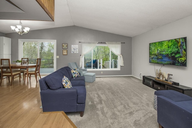 living room featuring an inviting chandelier, baseboards, plenty of natural light, and lofted ceiling