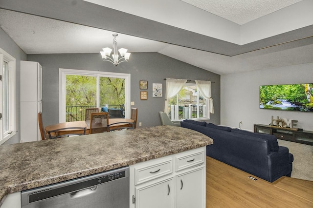kitchen with stainless steel dishwasher, open floor plan, light wood-type flooring, a chandelier, and white cabinets