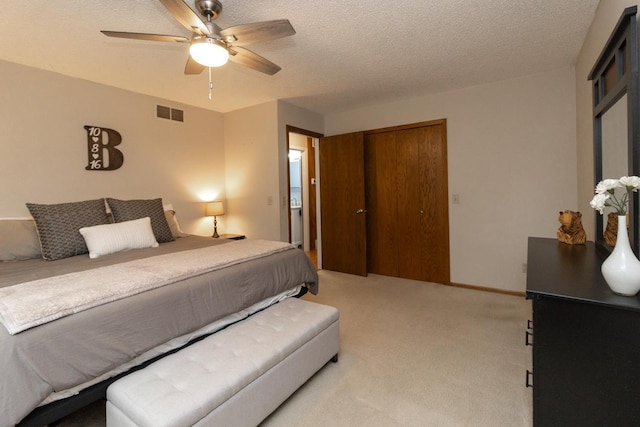 carpeted bedroom with a ceiling fan, a closet, a textured ceiling, and visible vents