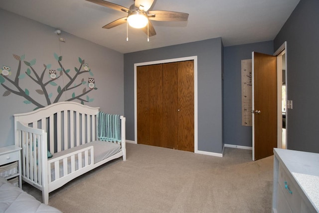 carpeted bedroom featuring baseboards, ceiling fan, a closet, and a nursery area
