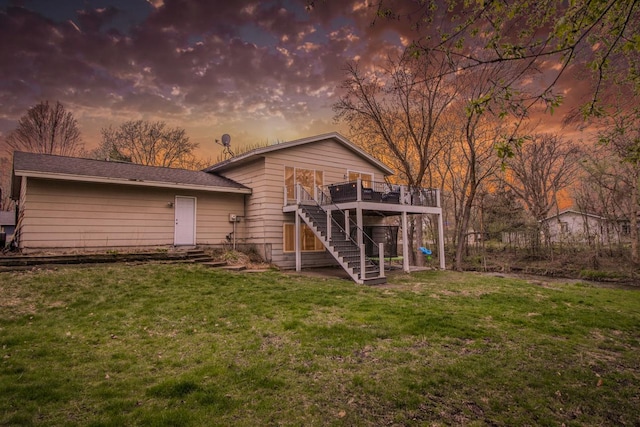 rear view of property with stairway, a deck, and a yard