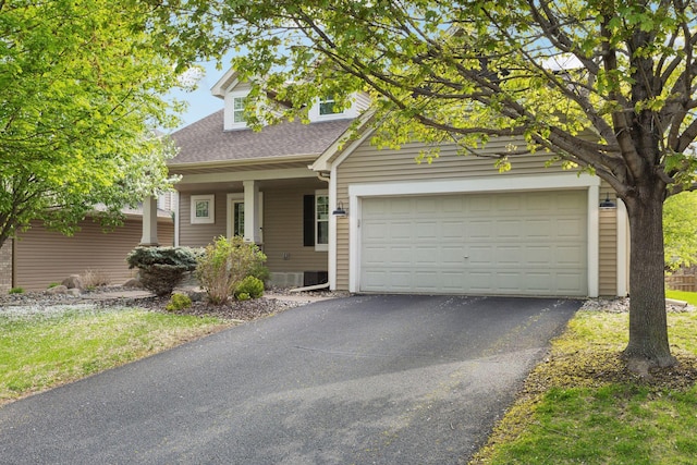 view of front of house featuring asphalt driveway, a shingled roof, covered porch, and an attached garage