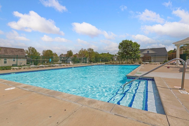 community pool with fence and a patio