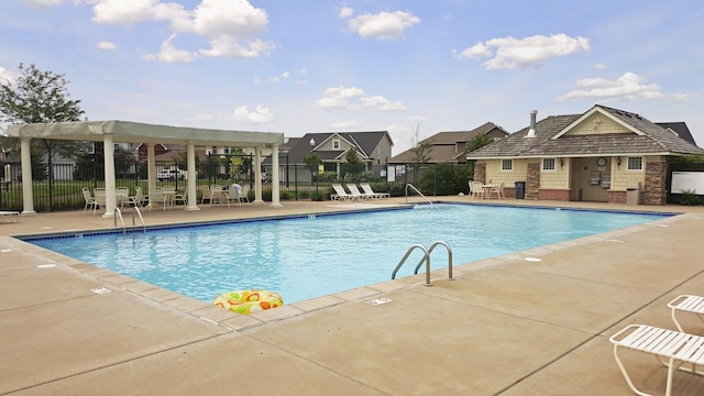 community pool with fence, a patio, and a residential view