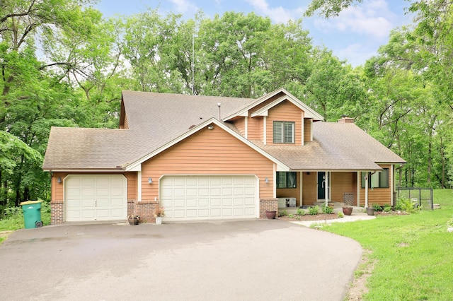 655 Trails End Rd, Minnetrista, MN 55364 - view of front facade featuring asphalt driveway, a garage, covered porch, a chimney, and a shingled roof