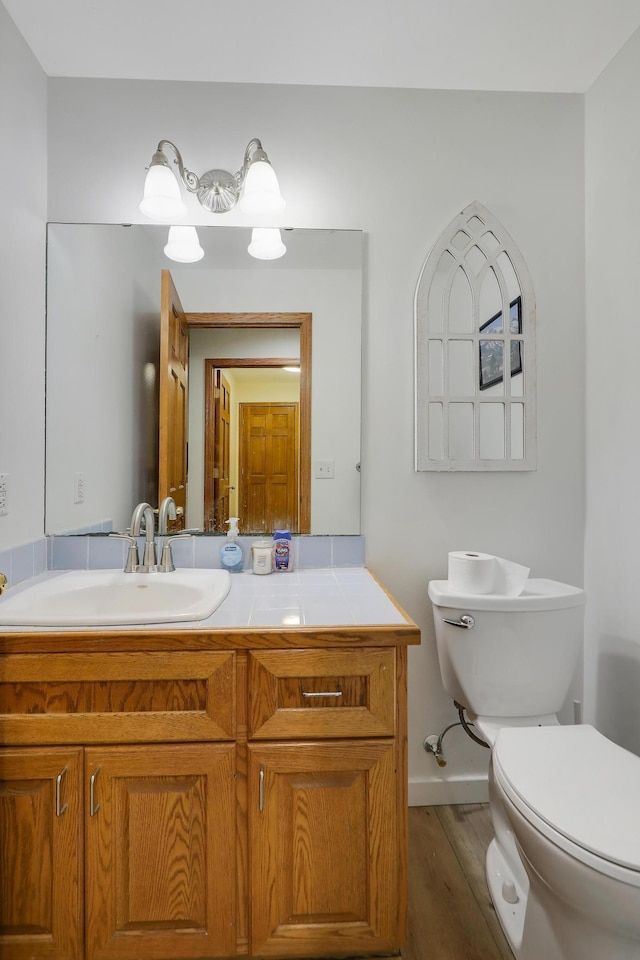 655 Trails End Rd, Minnetrista, MN 55364 - bathroom with toilet, vanity, wood finished floors, and baseboards