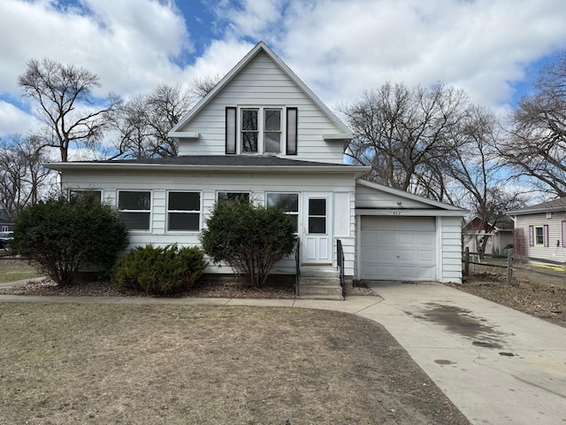 view of front of house with an attached garage, fence, and driveway