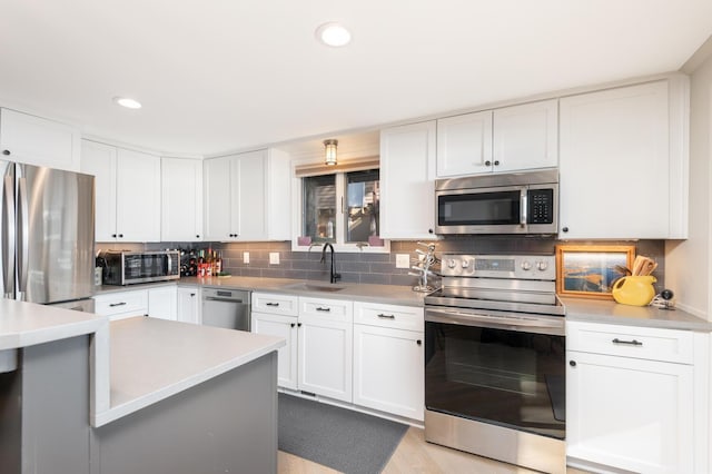 3008 Highland Blvd, Mound, MN 55364 - kitchen with appliances with stainless steel finishes, a sink, decorative backsplash, light countertops, and white cabinetry