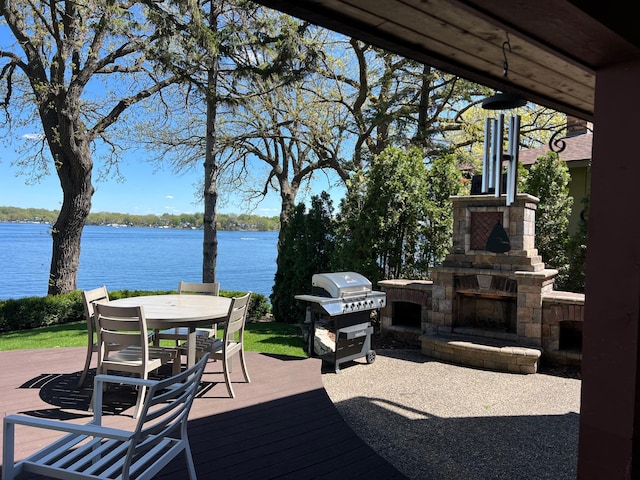 3008 Highland Blvd, Mound, MN 55364 - deck featuring an outdoor stone fireplace, a grill, a water view, and outdoor dining space
