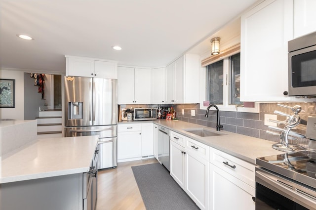 3008 Highland Blvd, Mound, MN 55364 - kitchen with stainless steel appliances, a sink, decorative backsplash, light countertops, and white cabinets