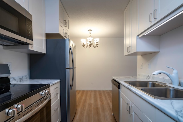 kitchen with light wood-type flooring, a sink, white cabinetry, and stainless steel appliances